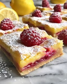 raspberry lemon bars with powdered sugar and fresh berries on the top are ready to be eaten