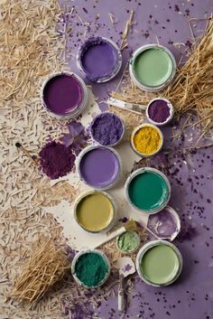 many different colors of paint are on the floor next to some hay and straw bales