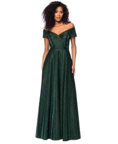 a woman in a long green dress standing on a white background wearing an off the shoulder gown