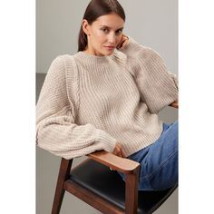 a woman sitting in a chair wearing a sweater