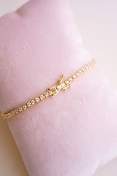 Meet your new favorite accessory: the Amelia Brilliant Cut Tennis Bracelet! We love how it effortlessly adds sparkle to your everyday look, whether you're dressing up for a date night or just want to feel a bit more glam. With its row of dazzling stones and eye-catching emerald cut center, all set in delicate 14k gold plating, this bracelet makes every outfit feel a little more special. The perfect blend of chic and sophisticated, the Amelia Bracelet lets you shine in your own unique way.BRACELE Bridal Jewelry Collection, Pearl Collection, Bridesmaid Bracelet, Birthstone Gifts, Bridal Bracelet, Bridal Necklace, Summer Jewelry, Bridesmaid Jewelry, Opal Jewelry