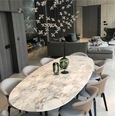 a marble dining table surrounded by grey chairs