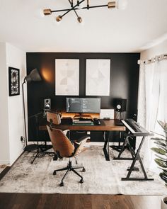 a home office with black walls and white carpeted flooring, two computer desks on each side of the room