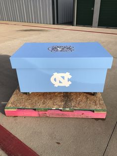 a large blue box sitting on top of a piece of wood