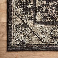 a black and white area rug on a wooden floor with a wood floor in the background