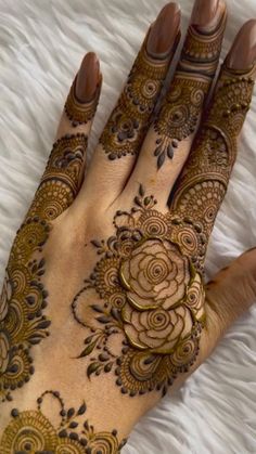 henna tattoo on the palm of a woman's hand with flowers and swirls