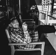 a man sitting in a chair on top of a balcony