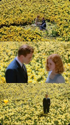 two people standing in a field full of flowers and one person is looking at the camera