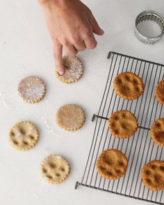 a person is making cookies on a cooling rack