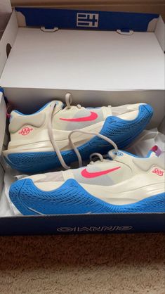 a pair of white and blue shoes in a box