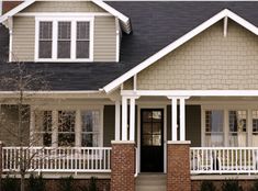 a brown house with white trim and black shutters on the front door is shown