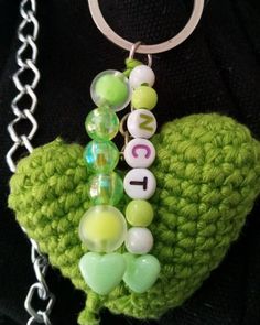 a crocheted keychain with beads and letters on it