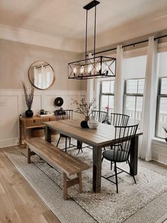 a dining room table and bench in front of a window