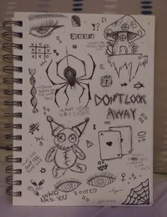 a spiral notebook with drawings on it and some words written in black ink next to an image of a spider