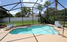 an enclosed pool area with chairs and tables