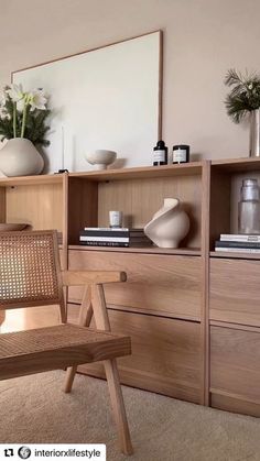 a wooden chair sitting in front of a book shelf filled with books and vases