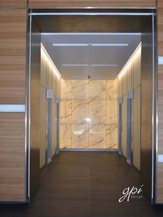 an empty elevator with marble walls and doors