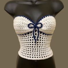 a white and blue crochet top on a mannequin headdress