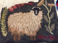 a rug with a sheep and flowers on it