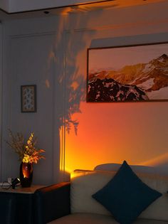 a living room with a couch, table and pictures hanging on the wall above it