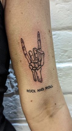 a person with a tattoo on their arm that says rock and roll in the middle