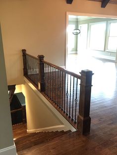 an empty living room with wood floors and railings