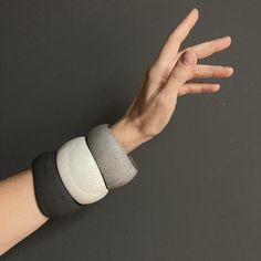 a person's arm with two wristbands on it and one hand in the air