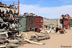 an old junk yard filled with various types of tires and other things in the dirt