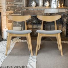 two chairs sitting next to each other in front of a fireplace