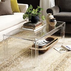 a glass coffee table sitting on top of a rug