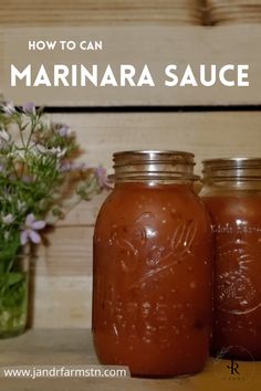 two jars filled with marinara sauce sitting on top of a table next to flowers