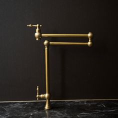 an old fashioned brass faucet on a marble countertop in a black room