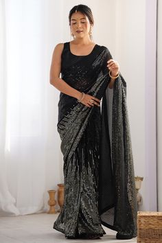 a woman in a black sari is holding her hand on the back of her shawl