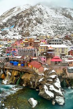 an aerial view of a city with mountains in the background and snow on the ground