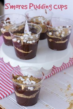 small cups filled with pudding and marshmallows on a cake platter for dessert