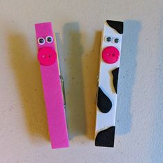 two pencils made to look like cows with eyes and nose painted on them, sitting next to each other