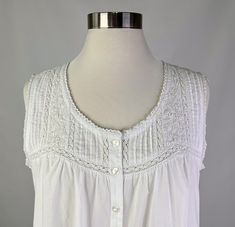 a woman's white blouse on a mannequin headdress with buttons