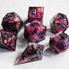 purple and black dices sitting on top of a table