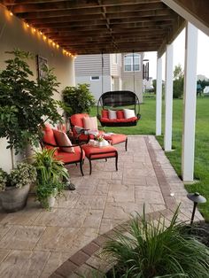 an outdoor patio with hanging chairs and potted plants