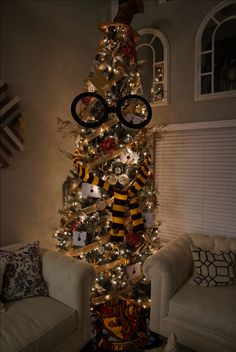 a harry potter christmas tree in the living room with glasses on top and hogwarts decorations