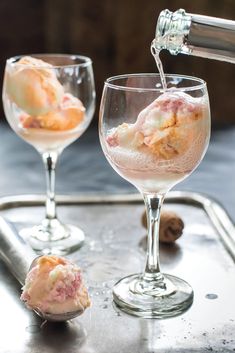 two glasses filled with ice cream sitting on top of a metal tray