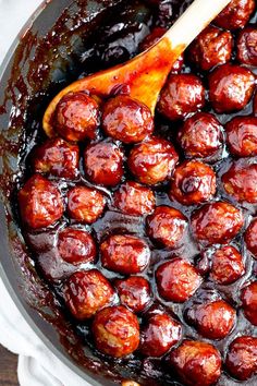 a wooden spoon in a pot filled with meatballs