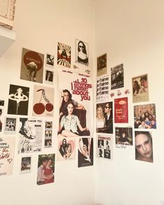 a wall covered in posters and pictures next to a window