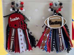 pair of football themed earrings with name tag and ball on earwires hanging from holder