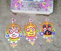 three colorfully painted masks are on the ground