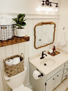 a bathroom with a toilet, sink and mirror in it's centerpieces