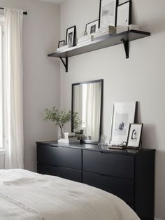 a bedroom with white walls and black furniture