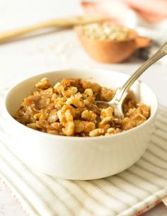 a white bowl filled with oatmeal on top of a striped place mat