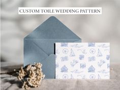 a blue envelope with a white paper on it next to a card and some dried flowers