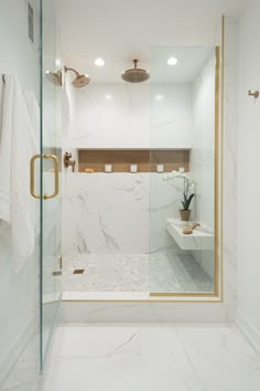 a bathroom with marble walls and flooring in the shower area, along with a glass door